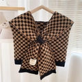 Close-up of checkerboard knit shawl with smile face patch on a wooden hanger - Camel and Black Checkerboard