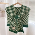 Detail of green checkerboard knitted shawl with smiley patch hanging on wood hanger - Green Checkerboard