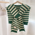 Detail of green and white striped knit shawl with a smile patch on a wooden hanger - Green Stripes