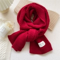 Vibrant red chunky knit scarf with white woven label in a cozy winter setting - 32x175cm / Red