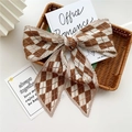 Pleated brown and white argyle pattern long scarf bow displayed on a tray - Pleated Two-Tone Rhombus Khaki