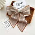 Brown and white striped pleated bow hair clip placed on a book inside a basket - Pleated Lines Coffee Beige