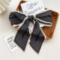 Pleated black and white silk scarf tied in a bow on a decorative wooden tray - Pleated Lines Black