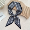 Foulard étroit en soie à motif paisley noir et blanc noué en nœud chic sur plateau en bois - Paisley Papillon Blanc (20F)