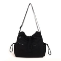 Minimalist black nylon drawstring bucket bag with adjustable shoulder strap and fashion label - Black