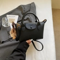 Minimalistische schwarze Handtasche mit Lychee-Struktur, Bären-Anhänger und Schultergurt - Schwarz ohne Anhänger