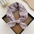 Chic lotus pink paisley cotton linen square scarf tied in a brown leather tray - Lotus Pink Peacock Feather Pattern