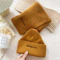 Conjunto de gorro y bufanda de punto amarillo jengibre con bordado negro en fondo beige - Naranja
