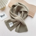 Close-up of oatmeal knitted scarf with ribbed texture and white fabric label detail - One Size / Dark Green