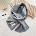 Detail of light grey ribbed knit scarf showing texture and handmade logo label - One Size / Light Gray