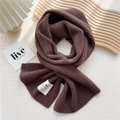 Close-up of thick dark brown knit scarf with vertical ribbed texture and hand-made label - One Size / Dark Brown