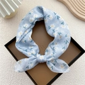Light blue floral cotton linen square scarf tied in a bow on a display card - Blue Six-Petal Flower