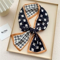 Floral and houndstooth twilly scarf with orange edges tied in a bow on a tray - Black Circular Floral (13X)