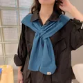 Chic blue knitted shawl wrap with decorative tag worn over a black shirt for styling - One Size / Haze Blue