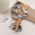 Narrow silk scarf in blue and orange featuring elegant botanical patterns on a wooden tray - Banana Leaf Blue Orange Stripe
