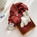 Two-tone knit scarf in brick red and cream white with stylish woven brand label - Rust Red White Striped