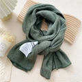 Dark green knitted scarf with ribbed texture and white fabric label for winter fashion - Green (MARI Tag)