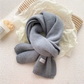 Thick grey knitted winter scarf with soft wool texture and minimalist brand label tag - Gray