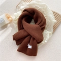 Thick knitted caramel brown winter scarf with ribbed edges on a warm minimalist background - Brown
