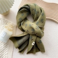 Winter knit scarf in olive green and navy blue floral pattern with a brand label - Flower Branch Green
