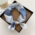 Pañuelo de seda geométrico azul y blanco elegantemente anudado en una caja de regalo negra - Azul Líneas 3D (10Z)