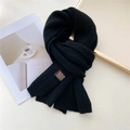 Solid black knitted scarf with ribbed texture and premium leather brand tag detail - Black (Brown Label)