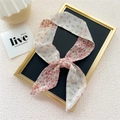 Floral skinny silk scarf with pink and yellow blossoms tied in a bow on a tray - Half Pink Floral
