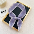 Narrow purple floral silk scarf tied in a bow on a display frame for women - Flying Feather Purple