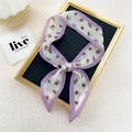 Elegant lavender-edged silk scarf with red cherry prints tied in a bow on frame - Tomato Pink