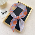 Narrow purple silk scarf with orange slice print tied as a bow in a display frame - Purple Orange Fruit