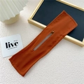 Detailweergave van de karamel oranje zijden knotmaker met centrale gleuf op witte stof - Oranje