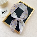 Narrow floral lavender twilly silk scarf tied in a bow on a black display board - Purple Water Wave Flower
