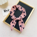 Foulard rose avec pois bleu foncé noué en nœud élégant sur support d'exposition - 8 Lignes de Pois Rose