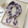 Elegant lavender silk scarf with sun and leaf pattern tied in a bow on a beige tray - Sun Shadow Pink (9)