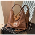 Detail der dunkelbraunen gesteppten Ledertasche mit silbernem M-Logo und Kettenriemen - Braun