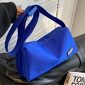 Vibrant blue nylon crossbody bag with wide strap and KERORO logo in a stylish casual setting - Klein Blue