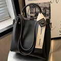 Borsa a secchiello nera con tracolla bianca Fashion e dettagli dorati su tavolo argento - Nero