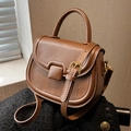 Elegant brown leather saddle bag with top handle and gold hardware in a chic variant - Brown