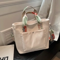 White canvas tote bag with floral patterned shoulder strap and front metal buckle pocket - White