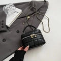 Mini sac seau matelassé noir avec chaîne dorée sur fond de blazer gris chic - Grand / Noir