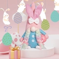 Detail of Easter gnome with pink bunny ears and rainbow braids holding a polka dot egg - Pink Style - Female (Holding Easter Egg)