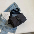 Minimalist black nylon crossbody bag with wide strap and buckle on casual denim background - Small / Black