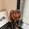 Brown quilted bucket bag with woven handle and drawstring closure in stylish caramel finish - Brown