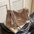 Beige pleated leather tote bag with silver chain strap and metal logo in city setting - Gray
