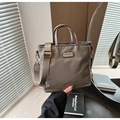 Detail of khaki nylon bucket bag with wide strap and metallic brand plaque - Gray