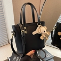Sac seau noir avec surpiqûres blanches, boucles dorées et pendentif d'ours mignon - Avec Pendentif / Noir