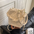Beige gesteppte Beuteltasche mit geflochtenem Griff und verstellbarem Umhängeriemen - Cremeweiß