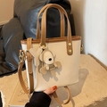 Beige bucket bag with brown trim and cute bear charm on a stone pedestal - With Pendant / Off White