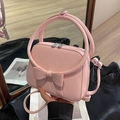Pink top-handle bag featuring a large bow detail and adjustable crossbody strap - Pink
