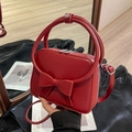 Chic red crossbody bag featuring a large bow detail and stylish top handle for women - Red